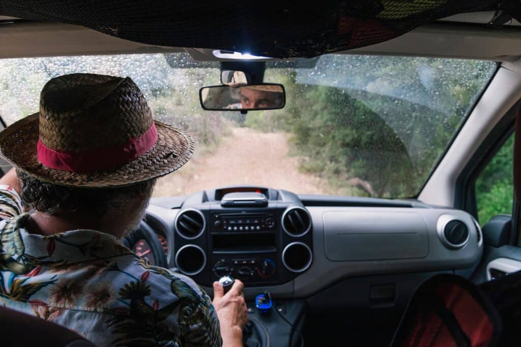 Man in a wicker hat driving down a dirt road | image for the Basics of Off Roading: How to Get Started blog.