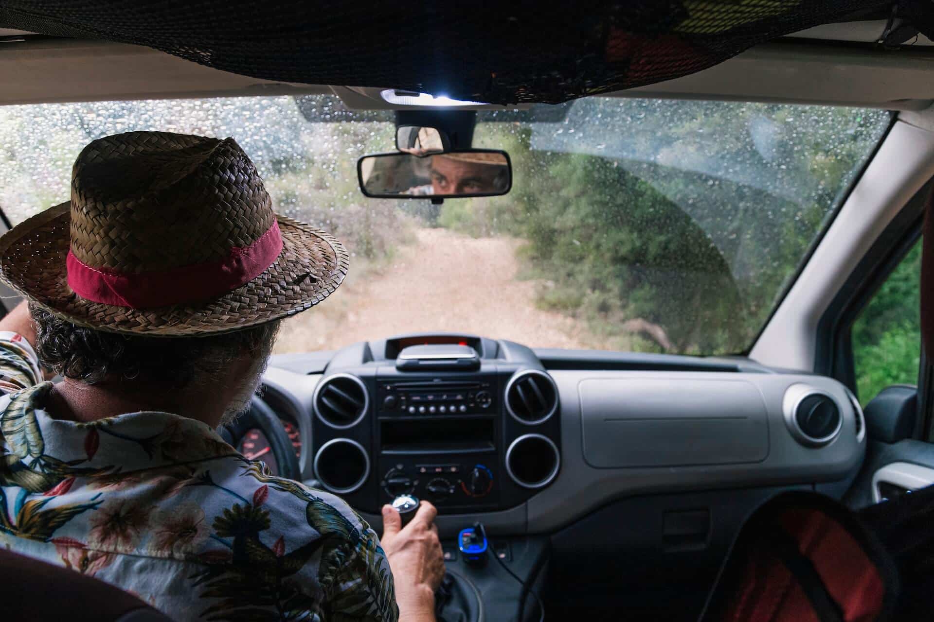 Man in a wicker hat driving down a dirt road | image for the Basics of Off Roading: How to Get Started blog.
